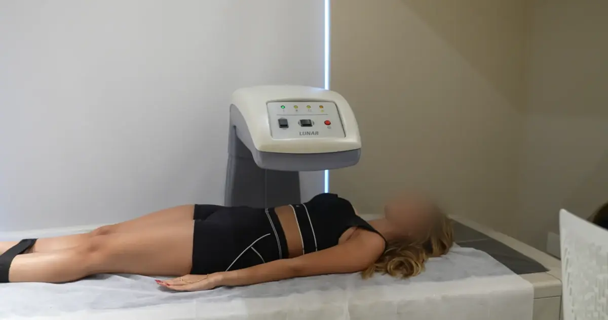 Paciente com o rosto desfocado deitada no aparelho de DEXA Scan do Instituto